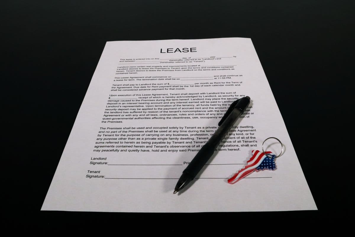 Lease agreement document with a pen, set against an American flag