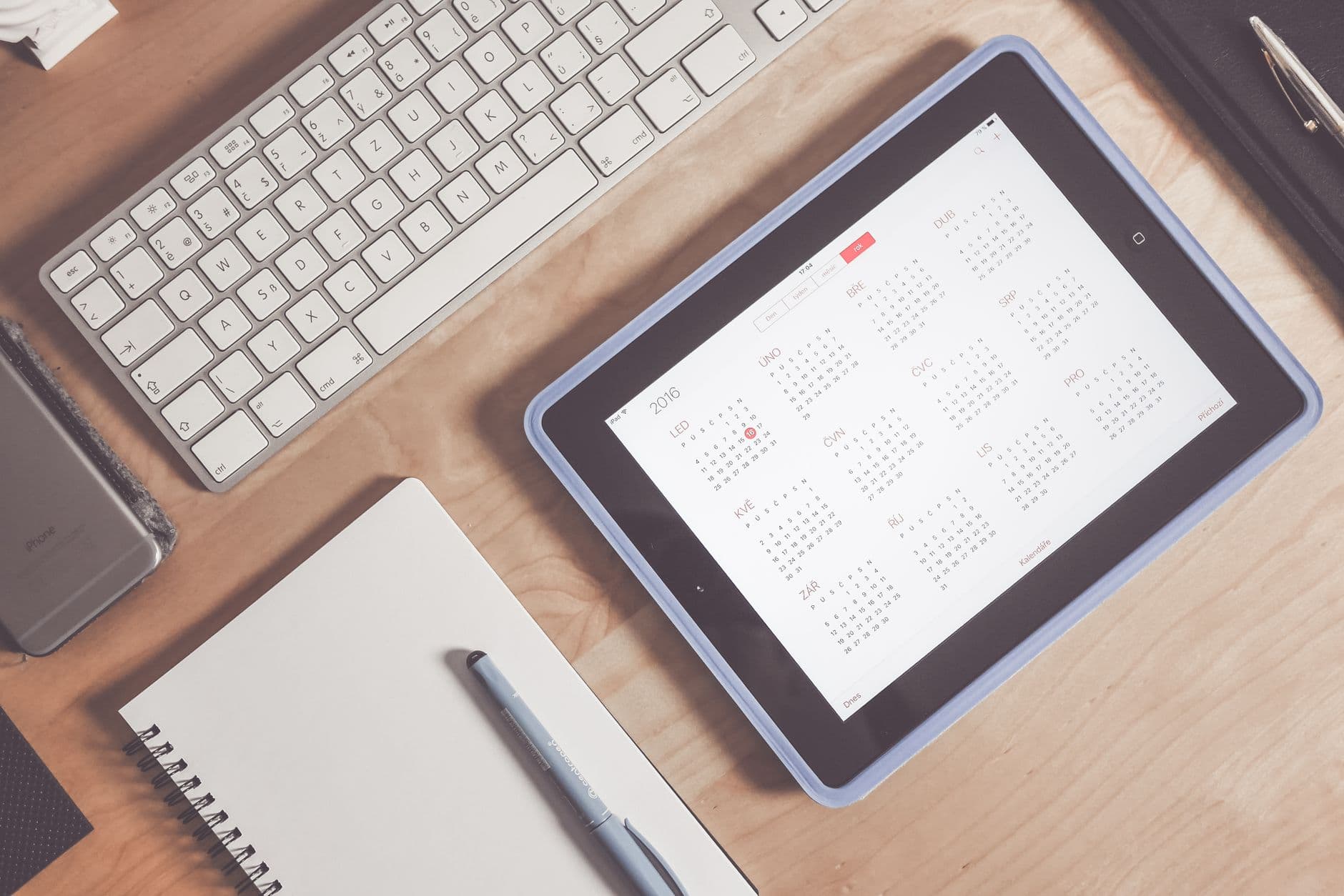 A tablet displaying a booking calendar on a tidy desk