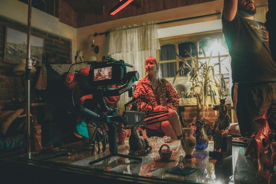 Film crew with a cinema camera shooting a scene inside a cozy home