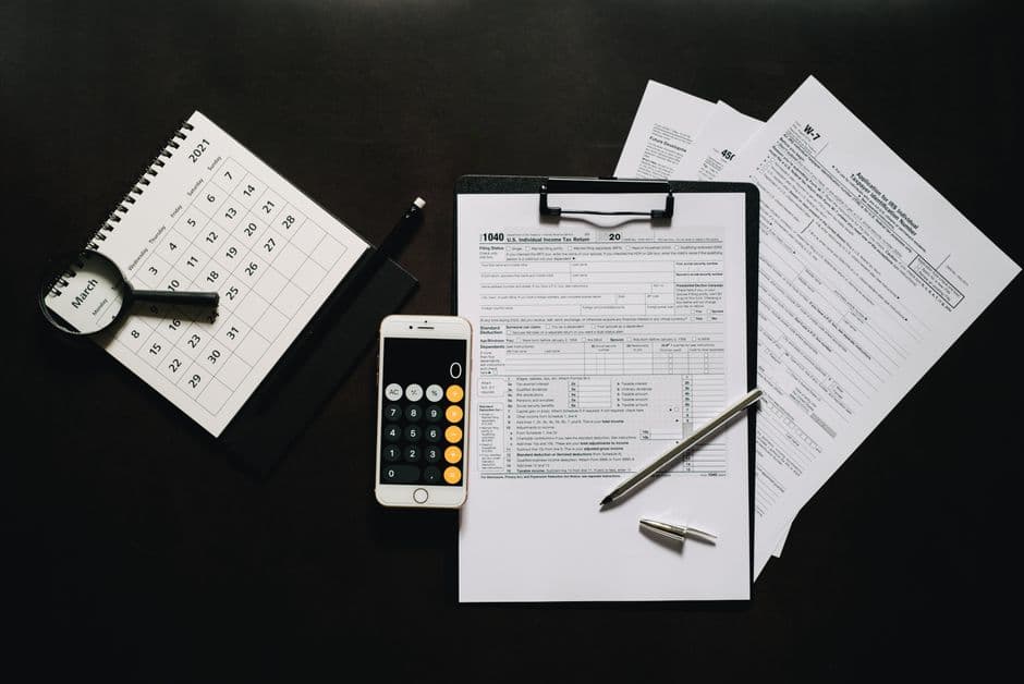 Flat lay of tax forms, calculator, and calendar for tax preparation