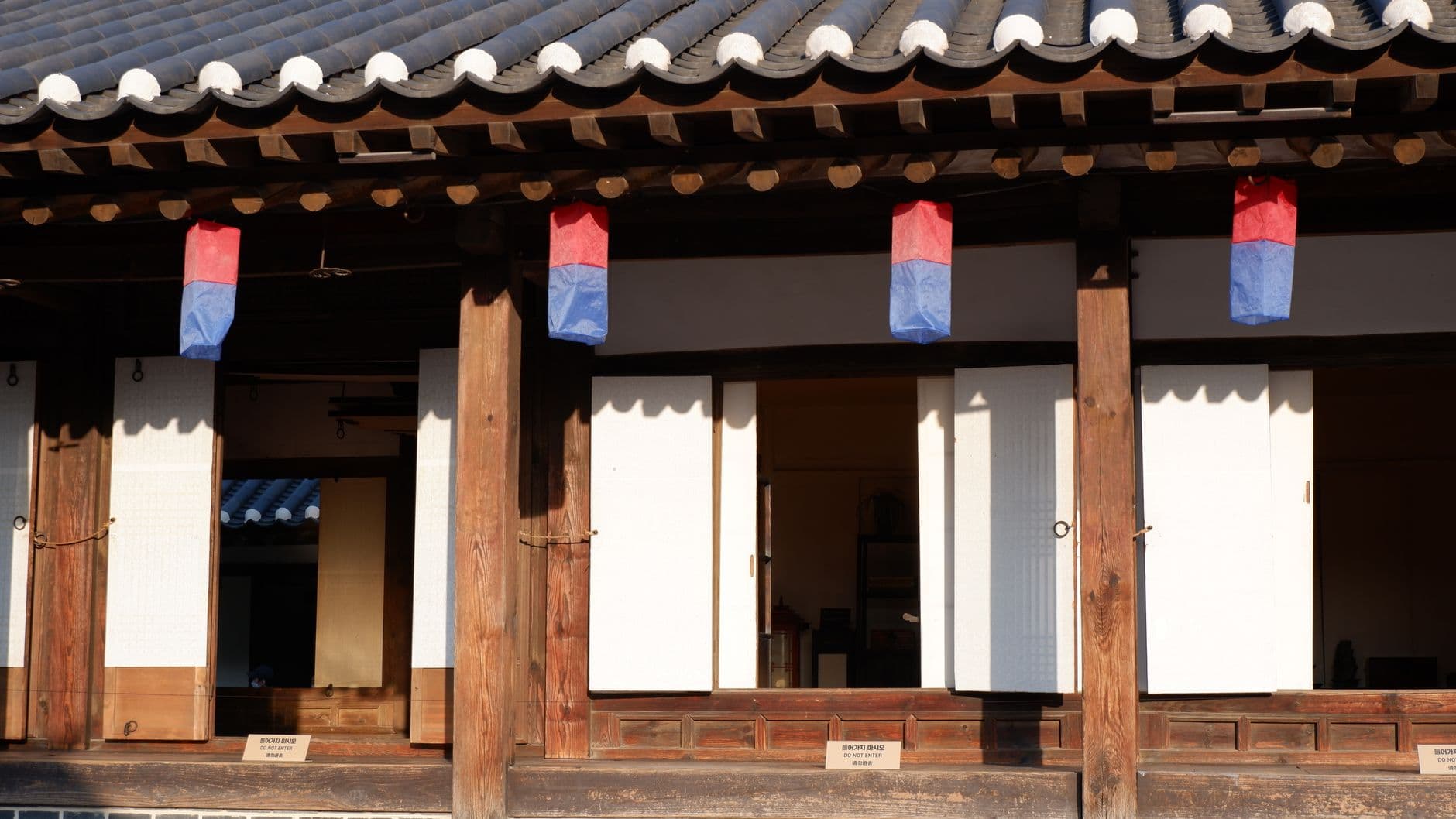 청사초롱이 걸린 전통 한옥 처마와 목조 기둥, 한지 문
