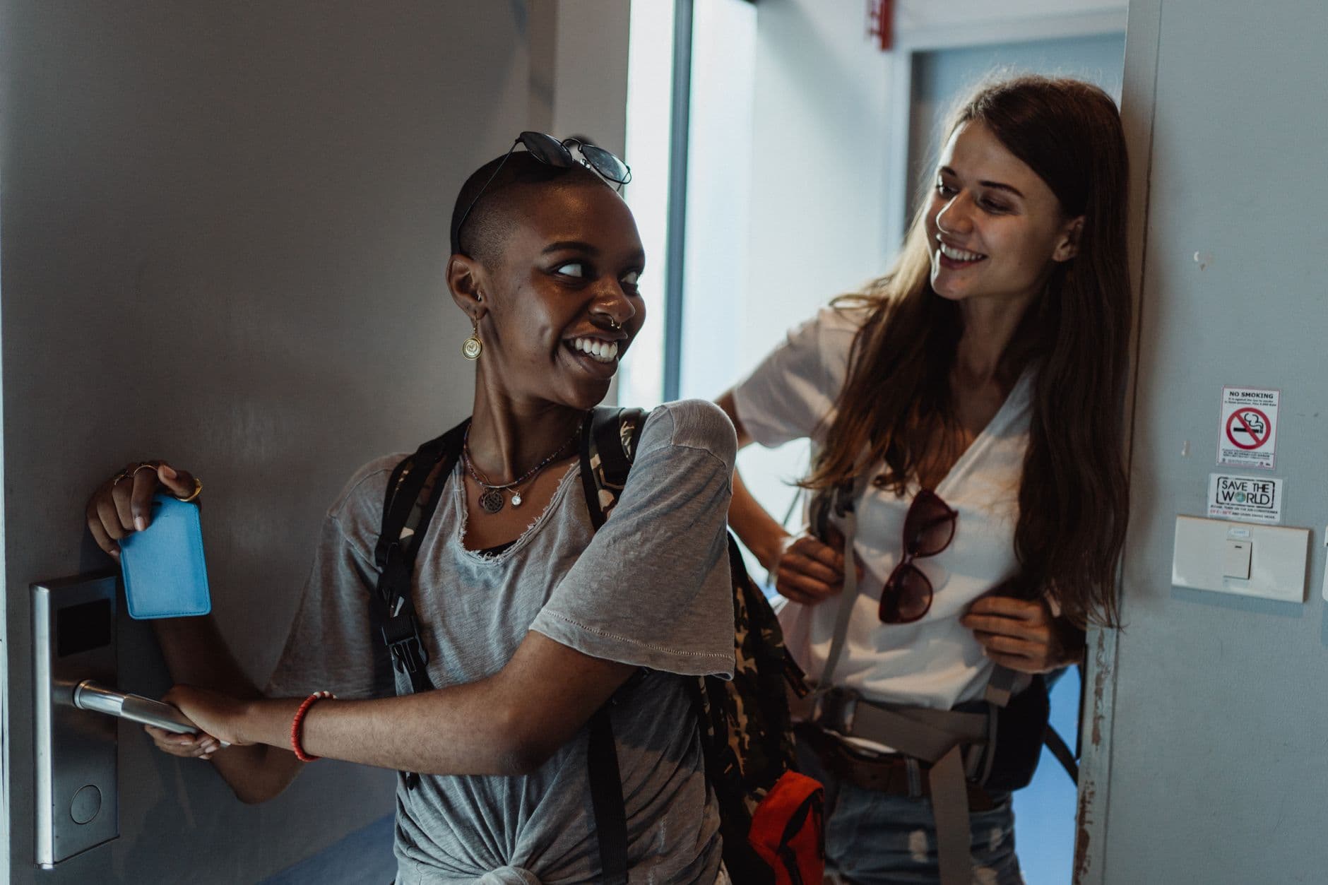 Two smiling guests entering a stay with a key